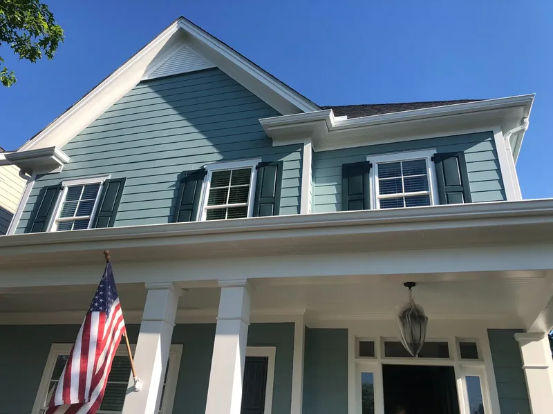 Two-story home with blue-green siding and white trim