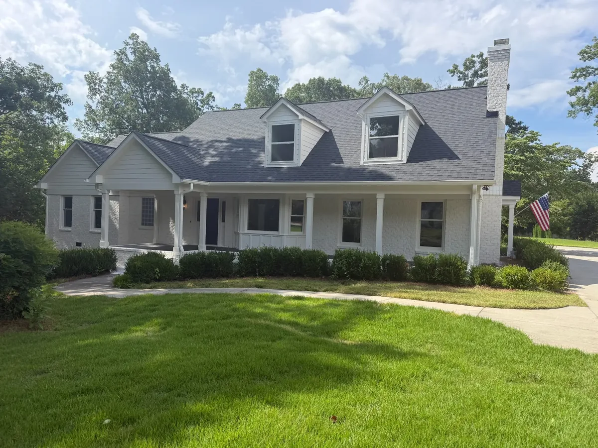 Painted white brick home with a wide front porch