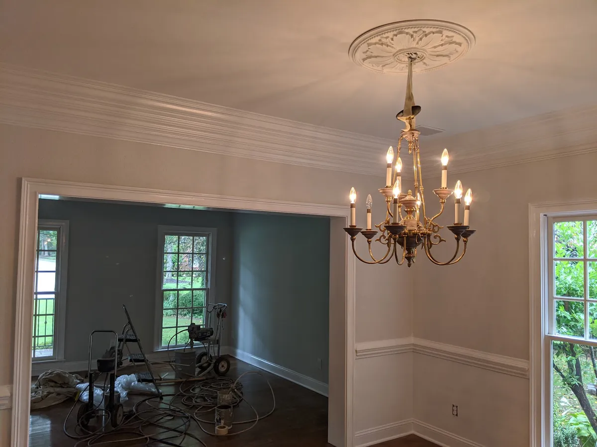 Dining room with fresh paint, crown molding and a chandelier