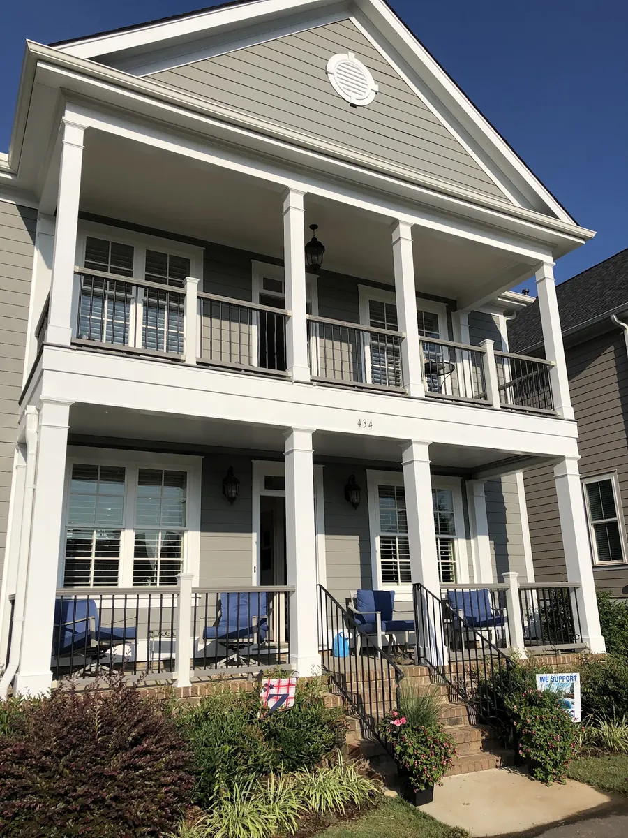 Two-story home with double front porches and white railings