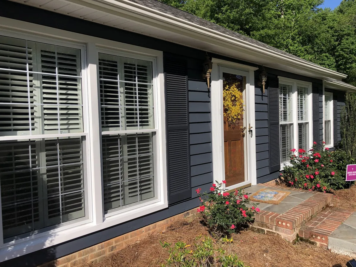 Ranch home painted navy with white trim and black shutters