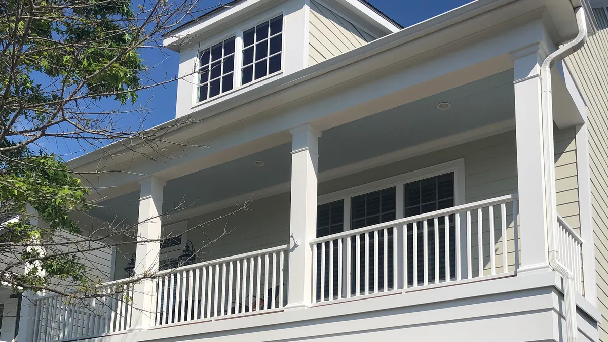 Second-story porch with freshly painted white columns and railings
