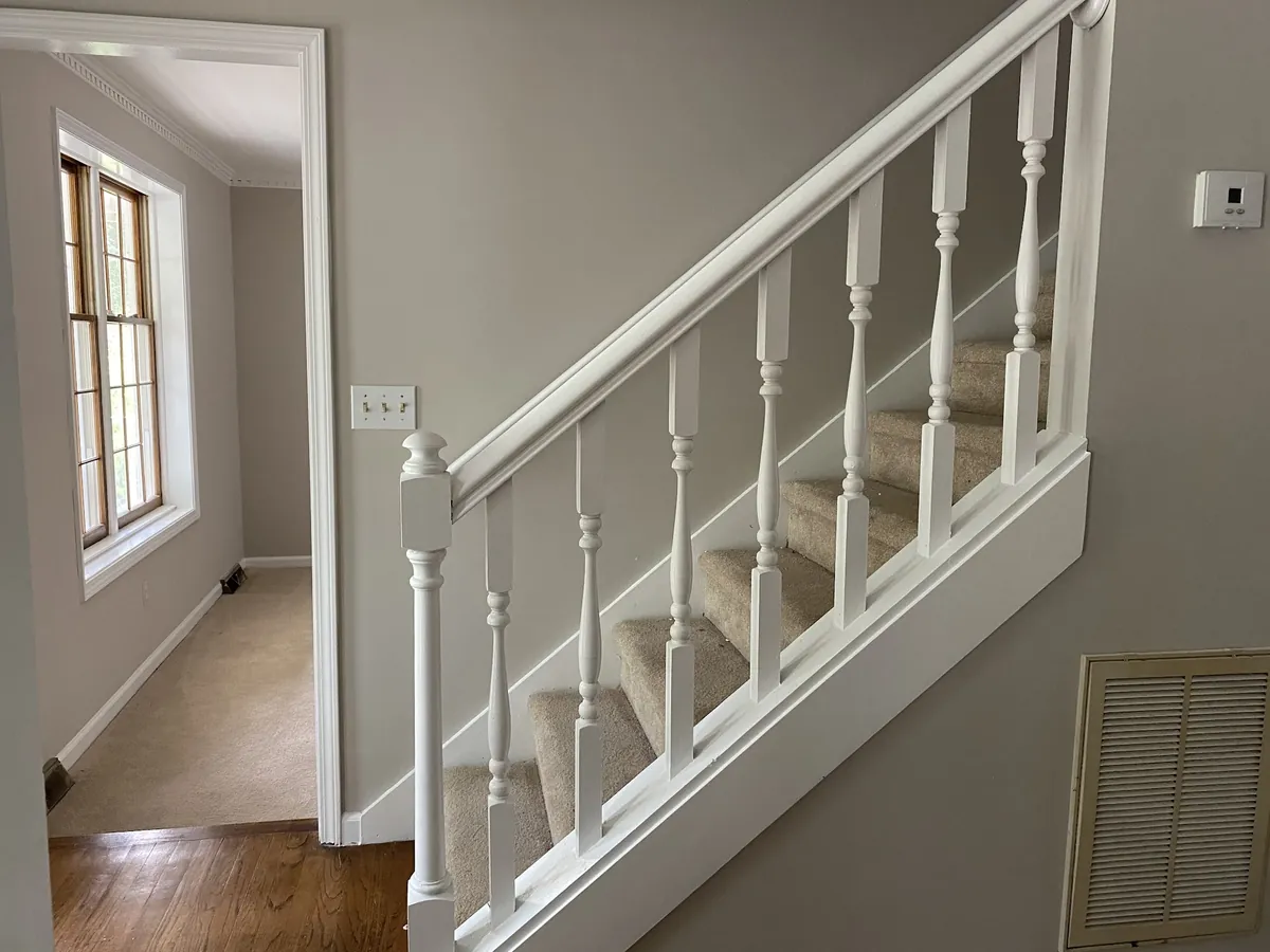 Staircase with freshly painted white balusters and handrail